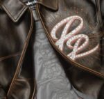 Celebrate heritage with the 47th Anniversary Dark Brown Jacket featuring premium leather, commemorative embroidery, and timeless streetwear design