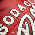 The Pelle Pelle Soda Club World Famous Red Jacket is a bold and iconic streetwear piece that represents the legendary Soda Club